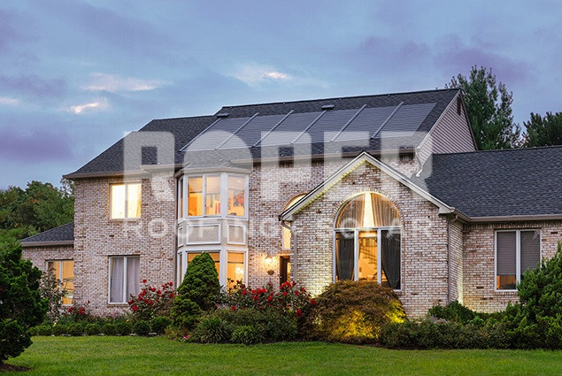 Modern brick house with solar panels and large windows at dusk