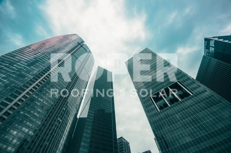 Modern glass skyscrapers viewed from below against cloudy sky in urban cityscape